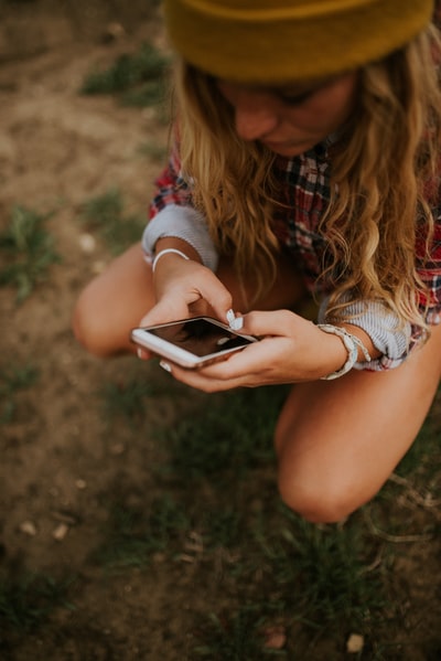 Squatting on the grass with a white woman of smartphones
